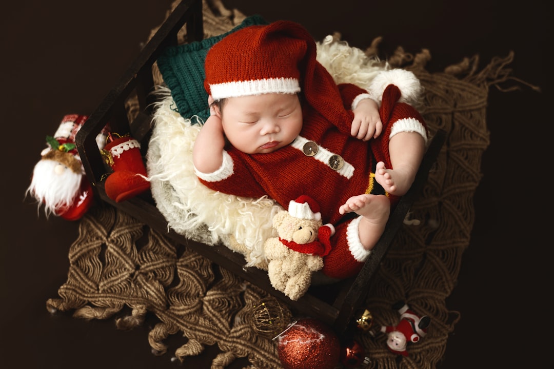 A baby dressed in a santa suit laying on top of a table