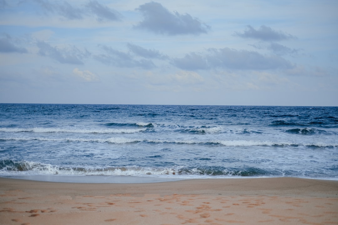 a beach with waves and clouds