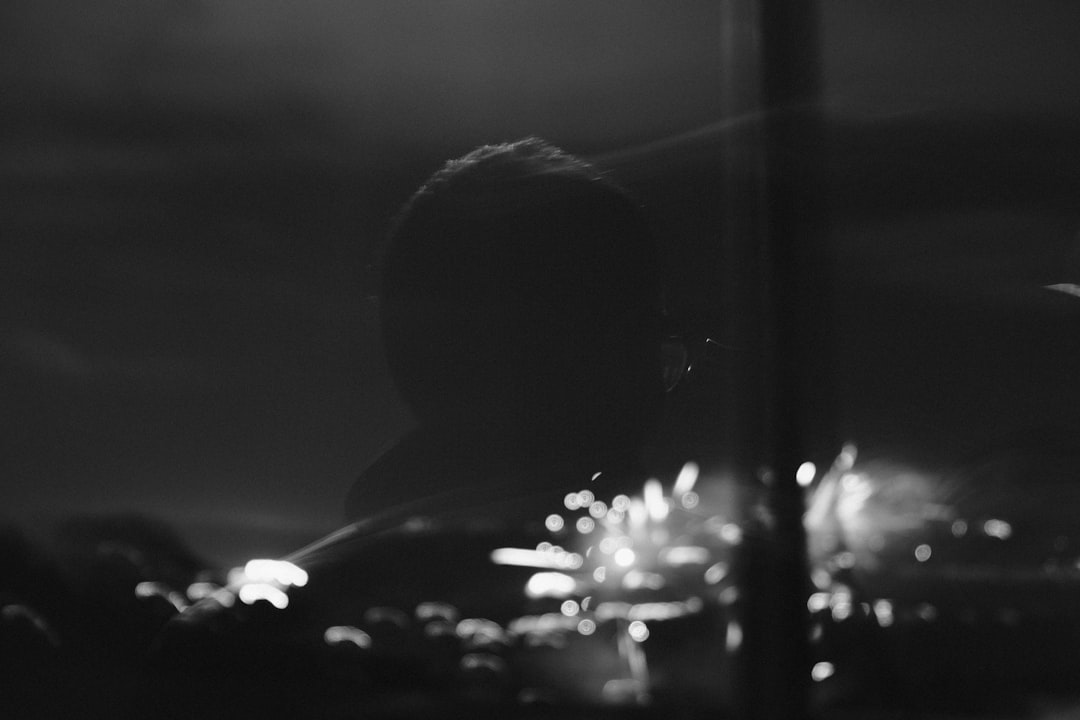 a black and white photo of a man's reflection in a window