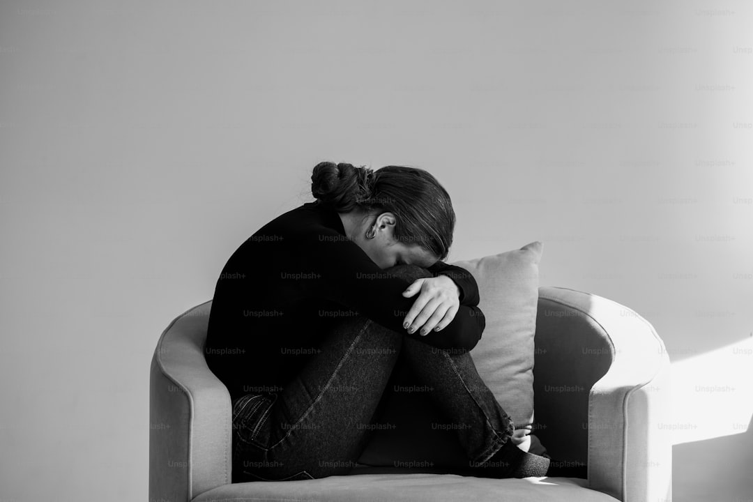 a black and white photo of a woman sitting on a couch