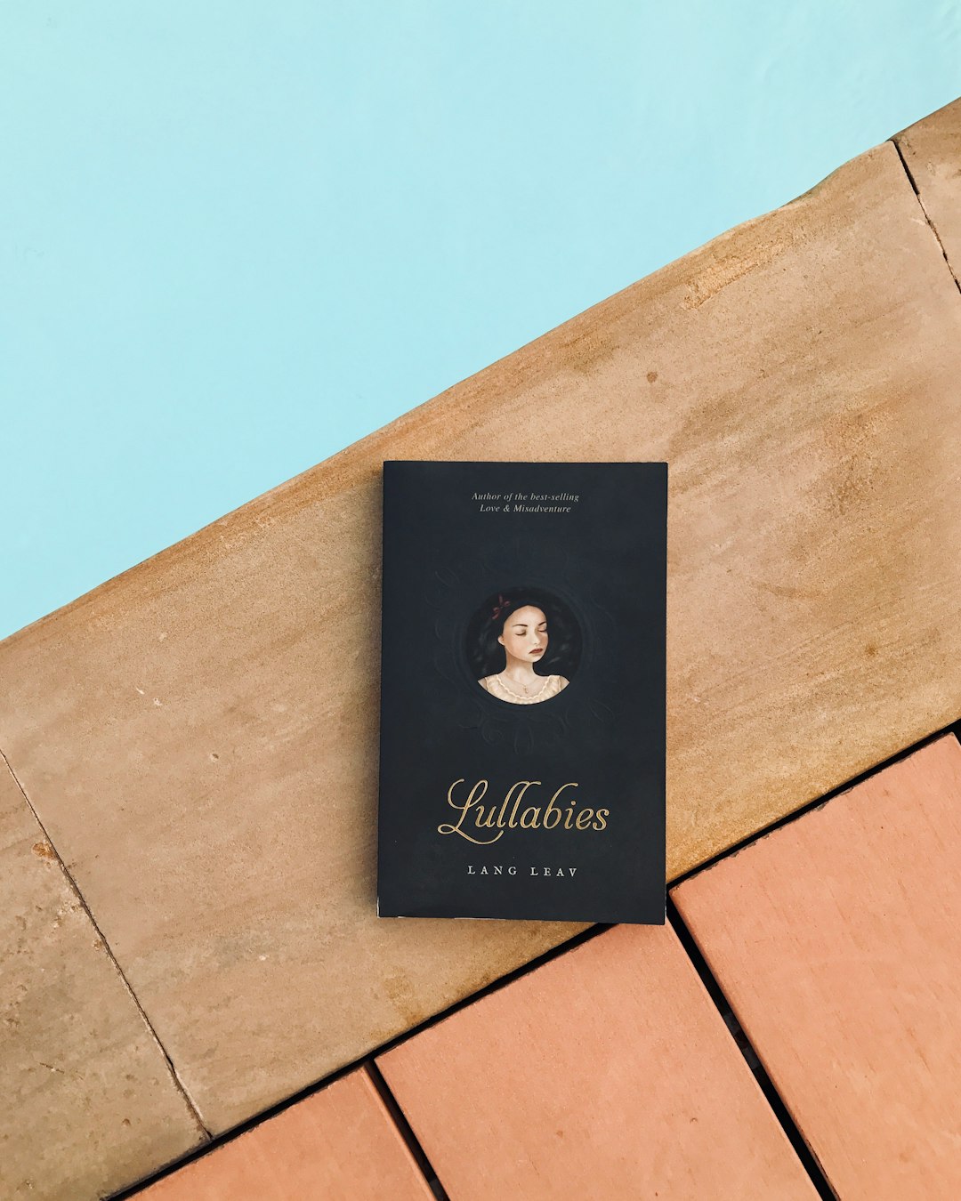 a book sitting on top of a wooden floor next to a pool