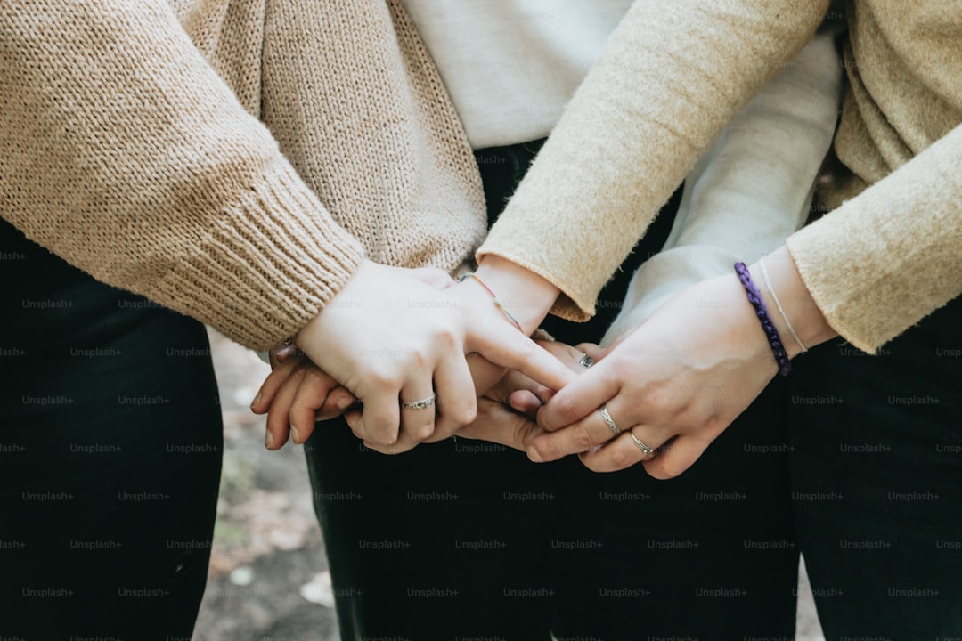 a close up of two people holding hands