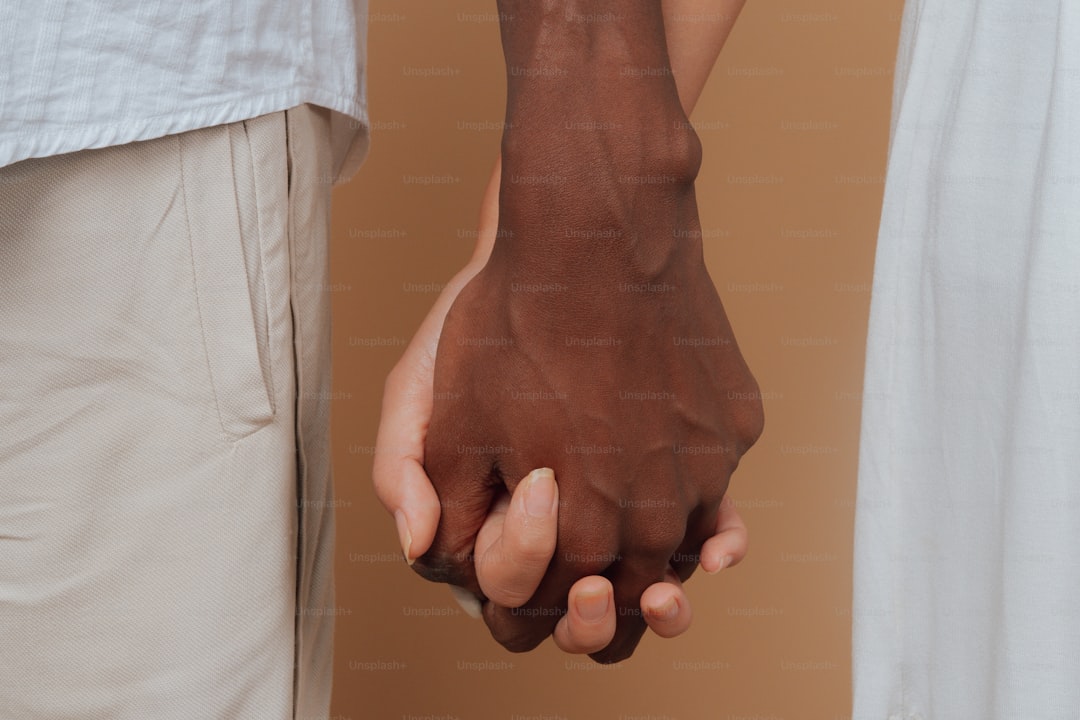 a close up of two people holding hands