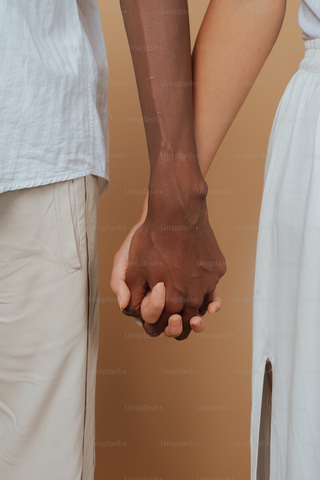 a close up of two people holding hands