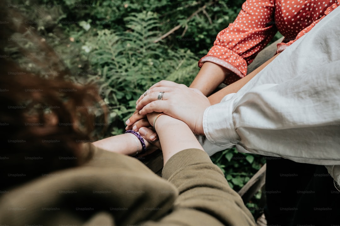 a couple of people holding hands over each other