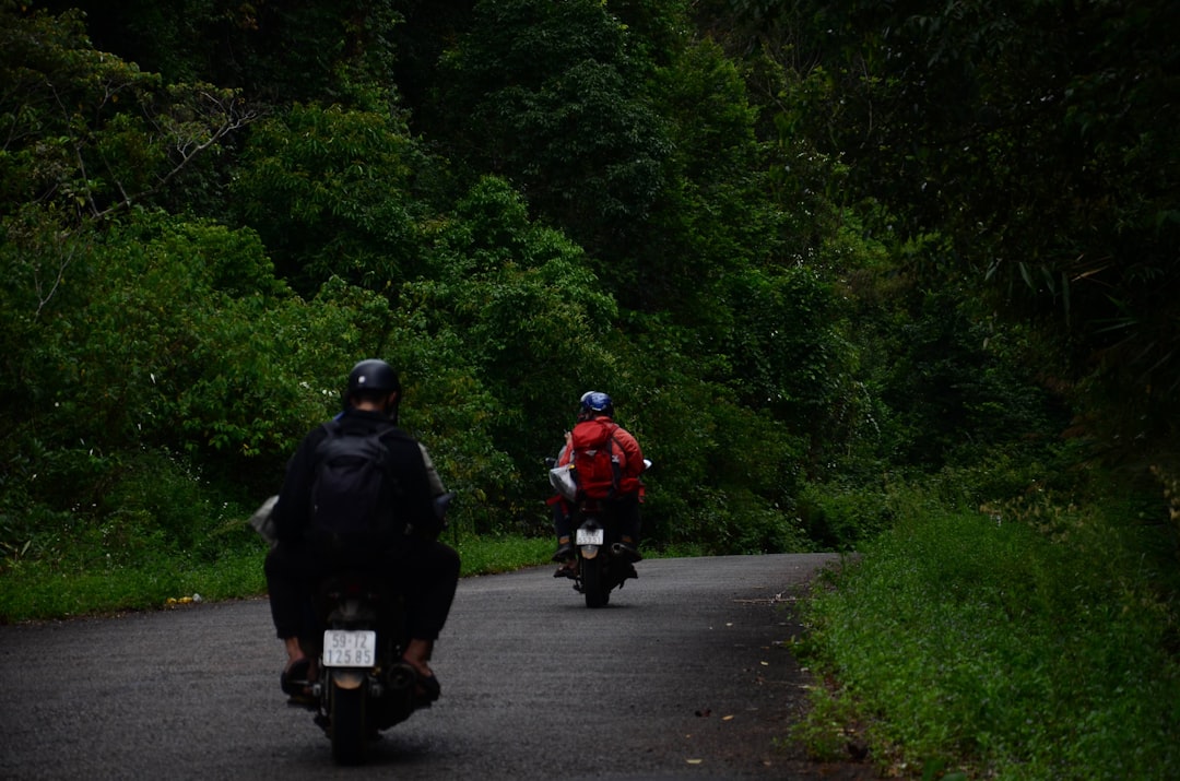 a couple of people riding motorcycles down a road