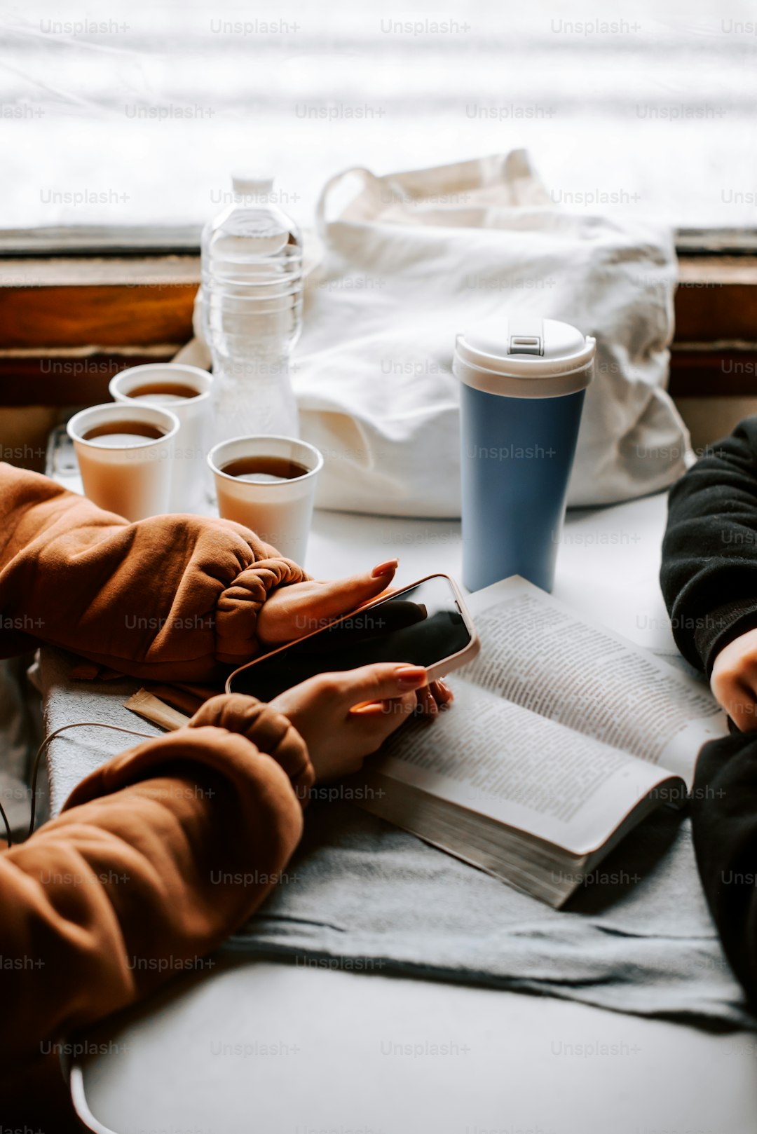 a couple of people sitting at a table with a book