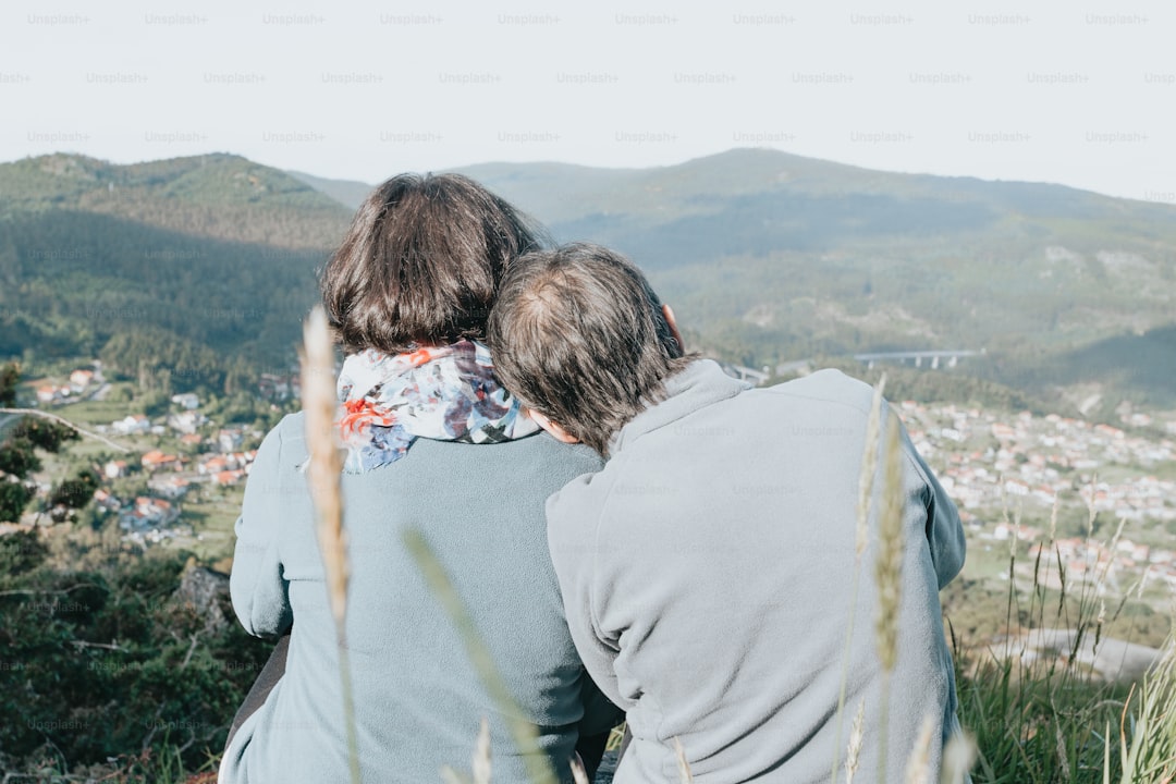 a couple of people that are sitting on a hill