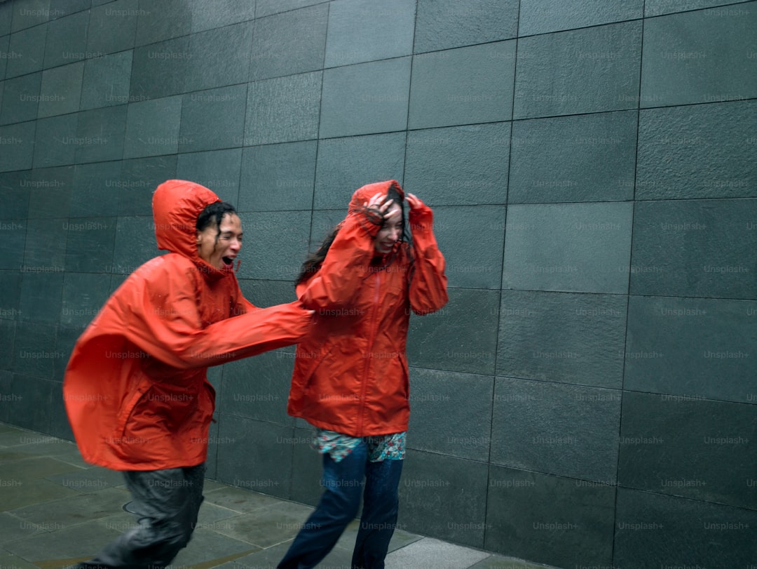 a couple of people that are standing in front of a wall