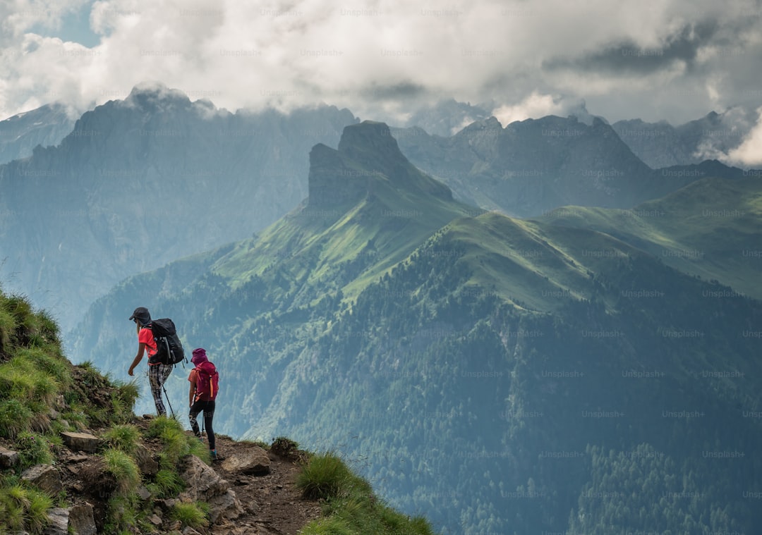 a couple of people walking up the side of a mountain