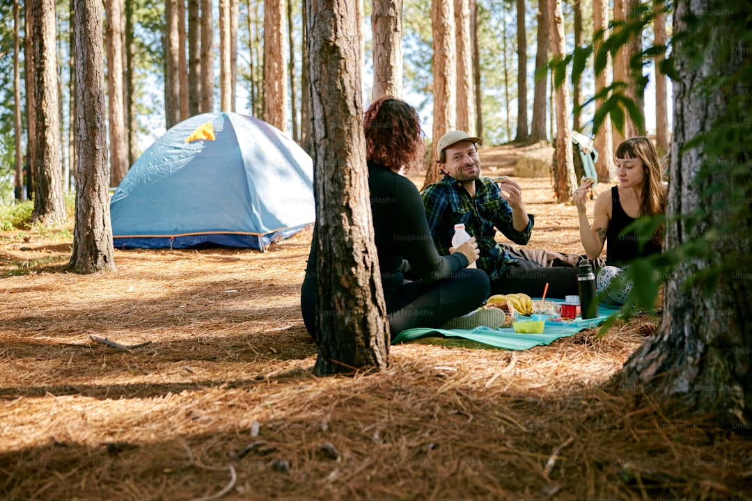 a group of people sitting on the ground in the woods