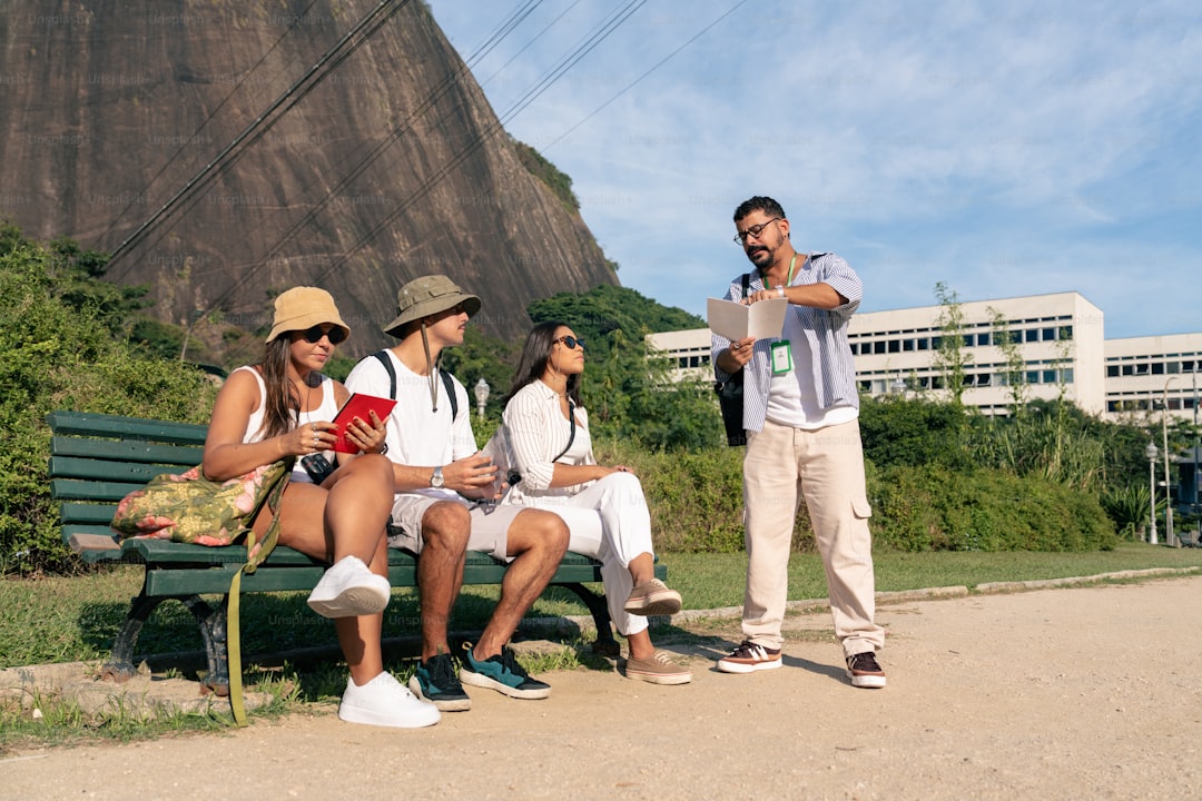 a group of people sitting on top of a green bench