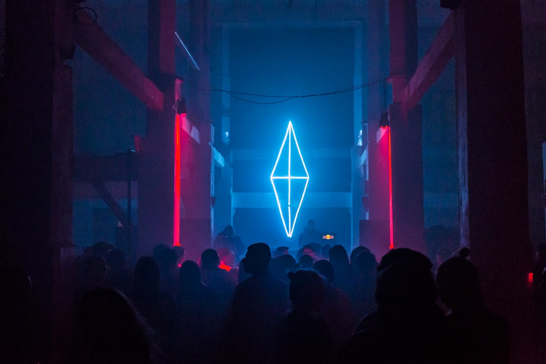 a group of people standing in front of a neon sign