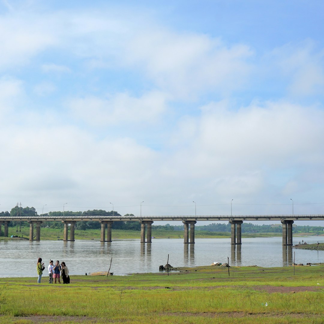 a group of people standing next to a body of water