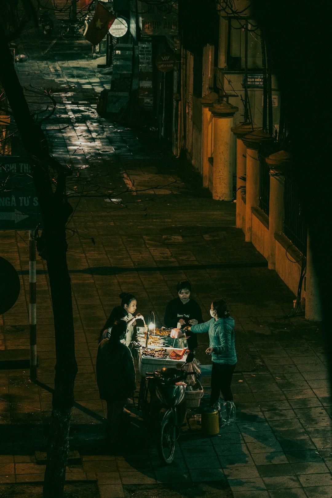 A group of people walking down a street at night