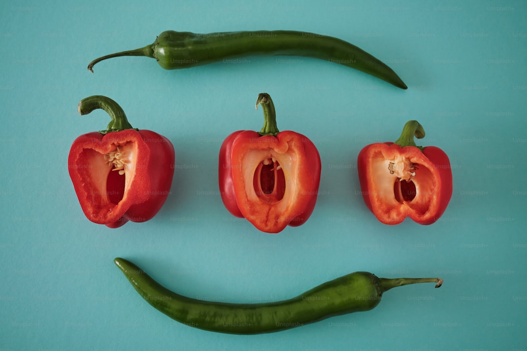 a group of red peppers with a green pepper in the middle