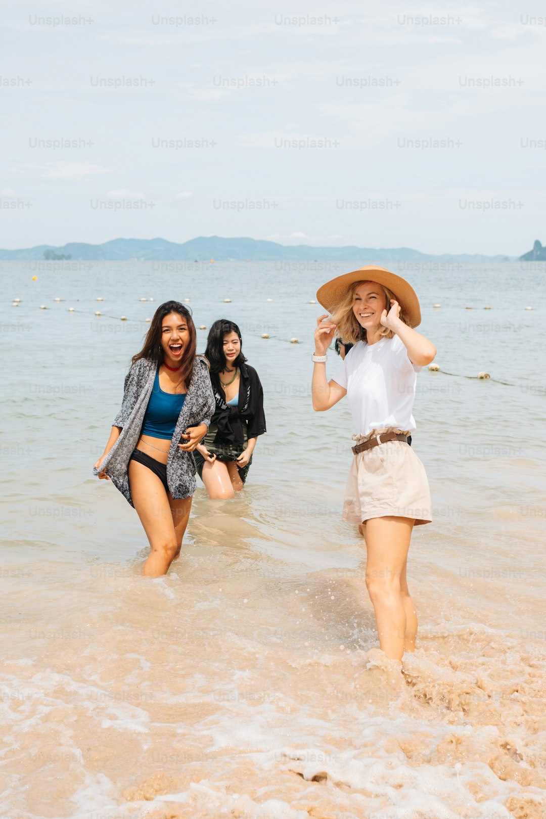 a group of women walking across a sandy beach