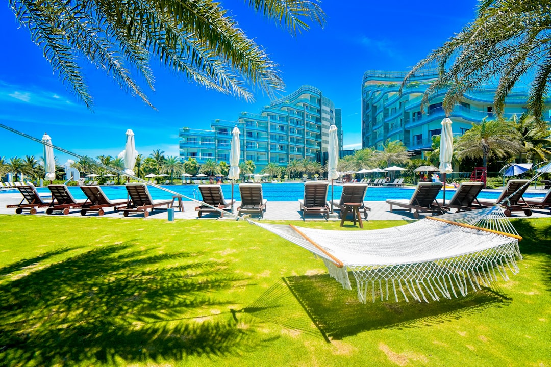 a hammock sitting in the grass next to a swimming pool