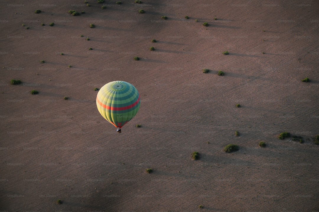 A hot air balloon flying over a sandy beach