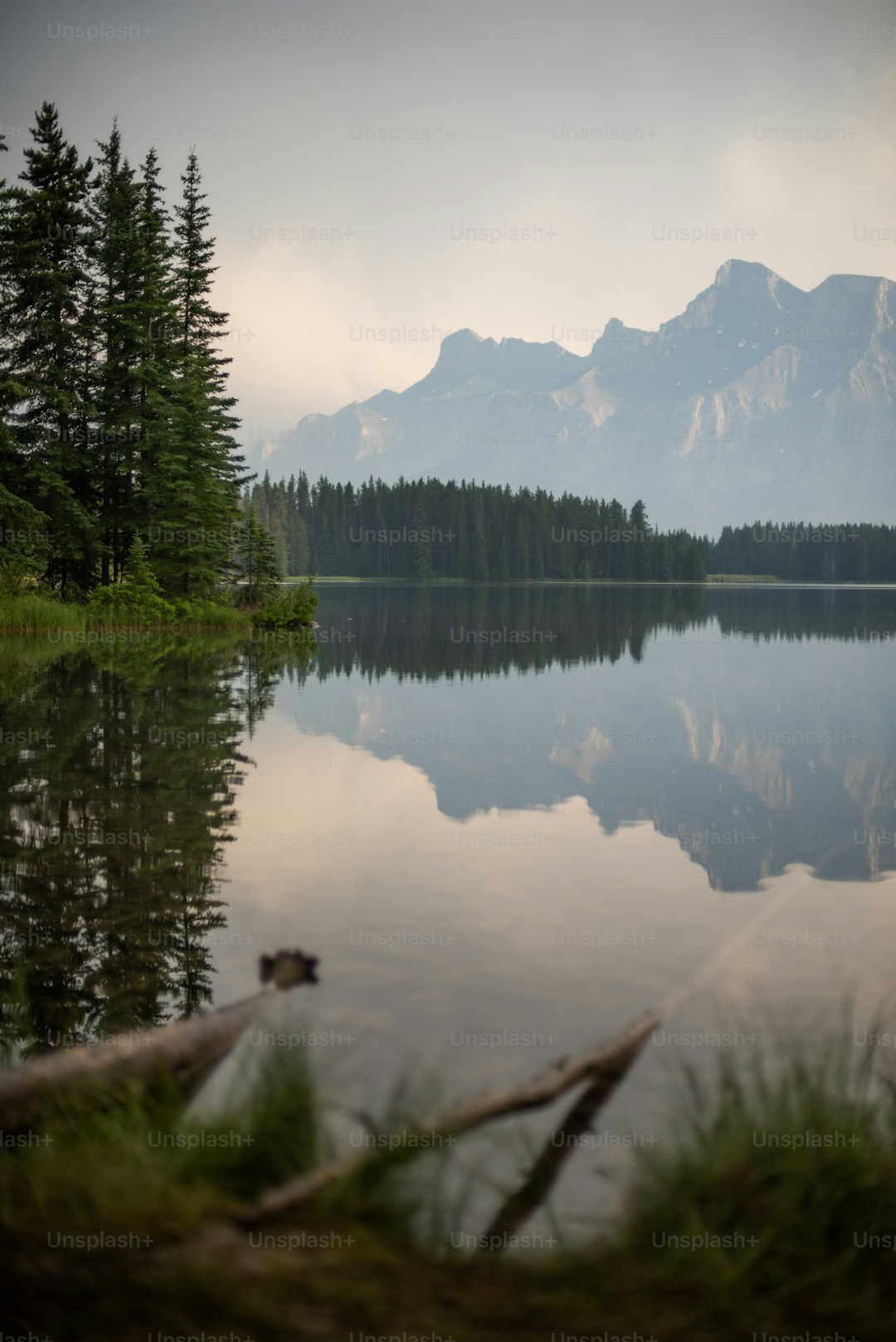 a lake with trees and mountains in the background