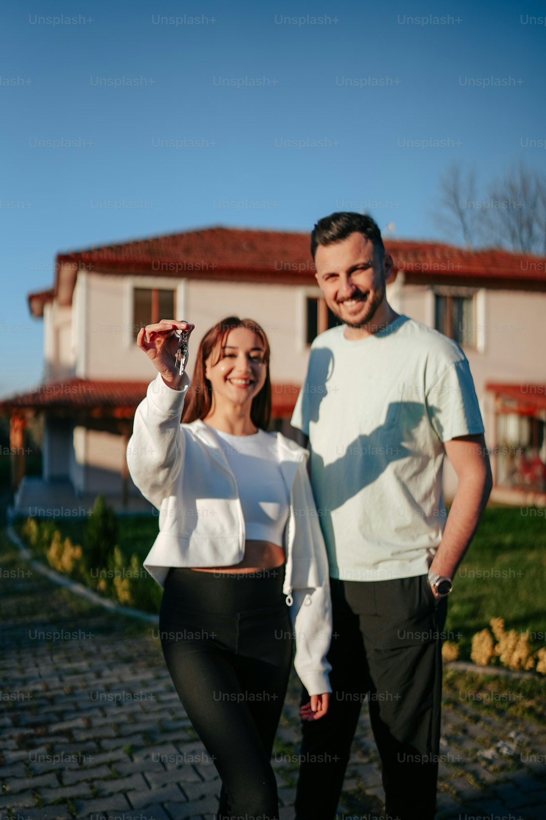 a man and a woman standing in front of a house