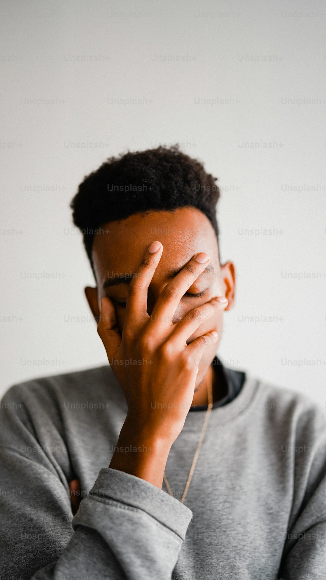 a man covering his face with his hands