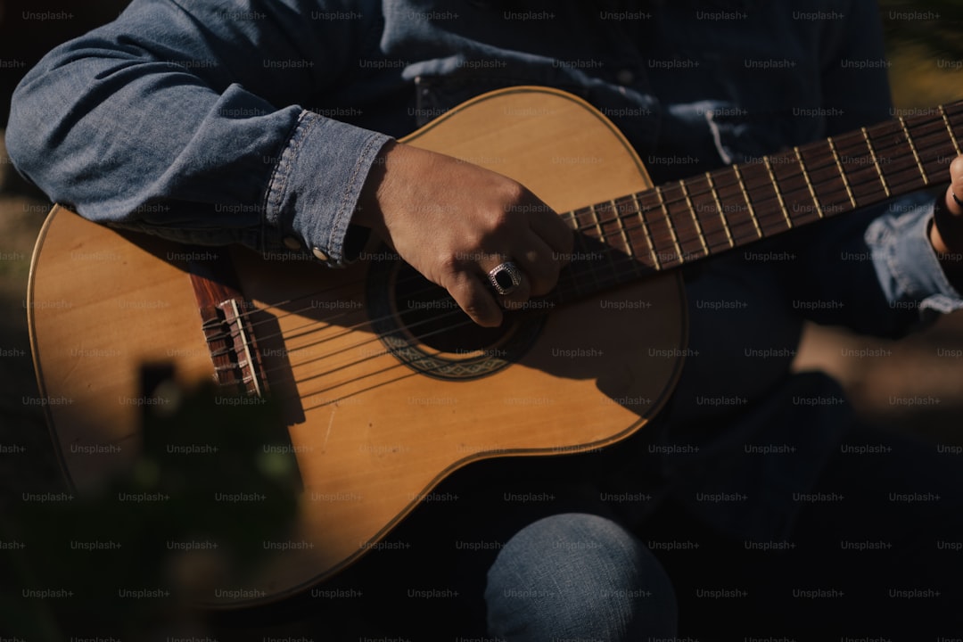 a man is playing an acoustic guitar outside