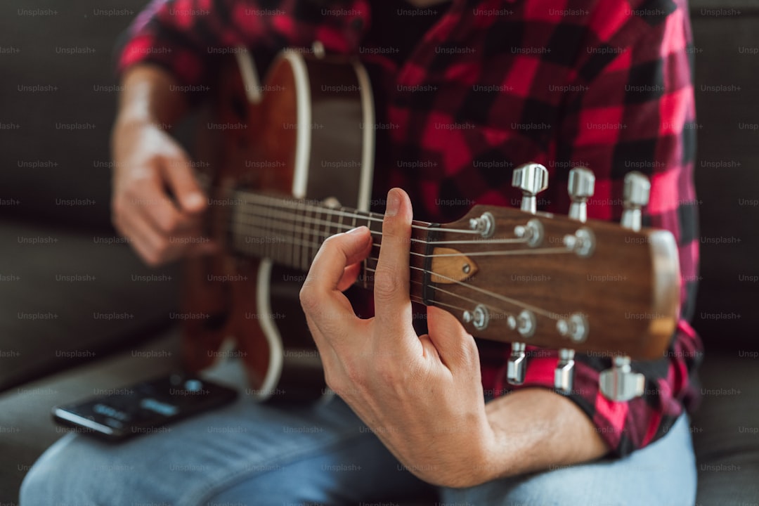 a man sitting on a couch playing a guitar