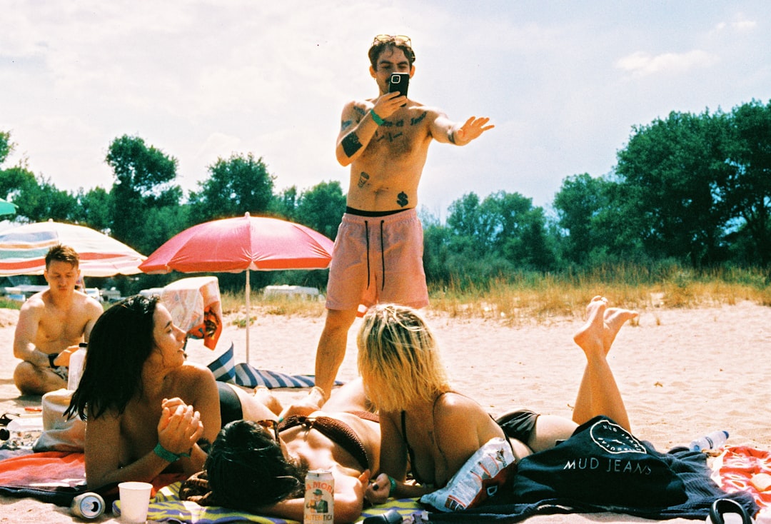 A man standing on top of a beach next to a group of people