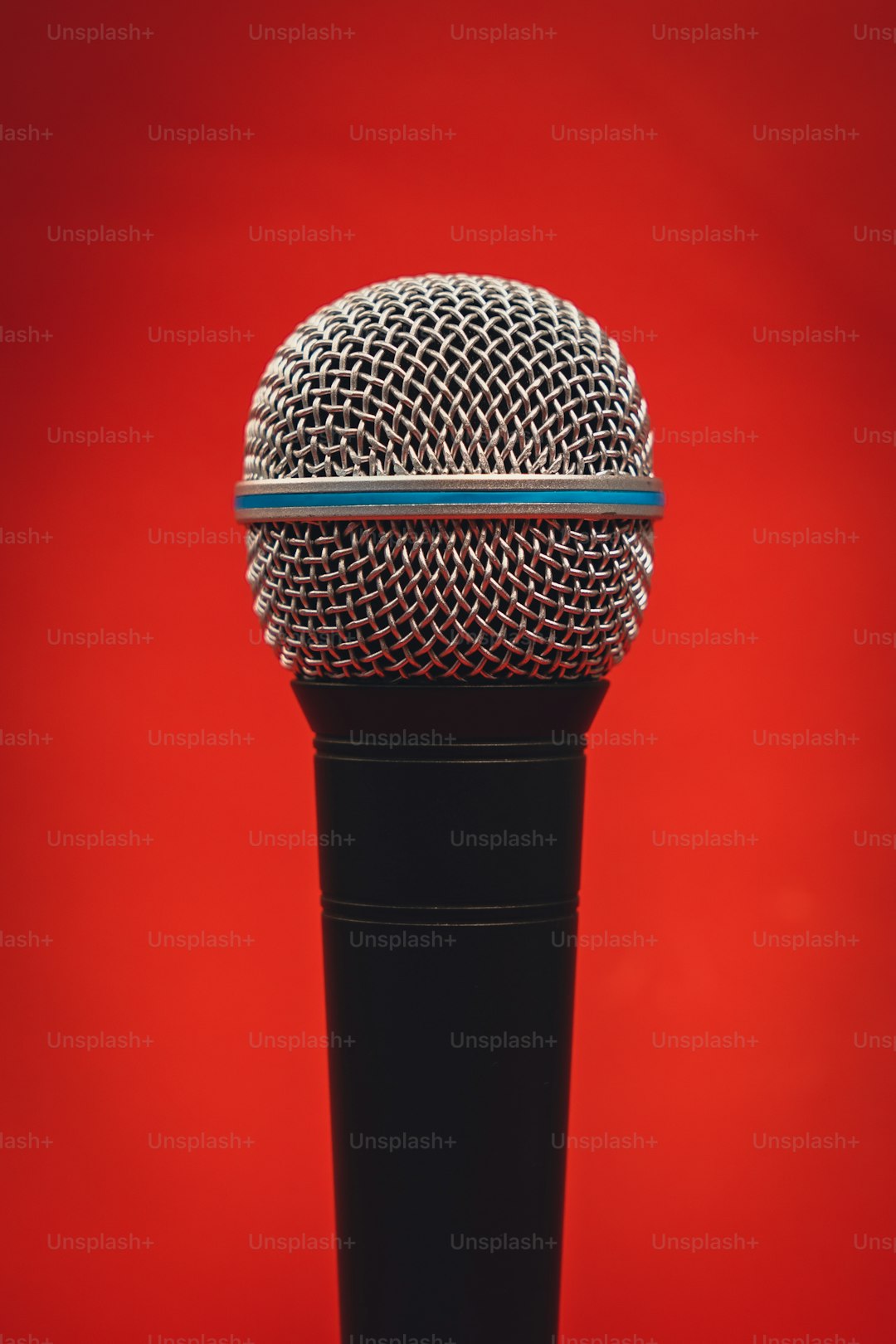 a microphone on a stand against a red background