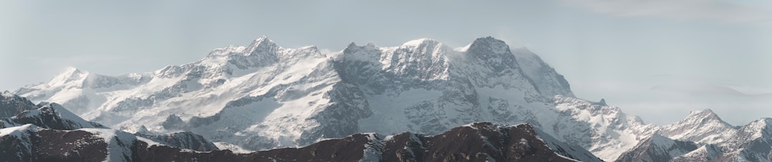 a mountain range covered in snow and clouds