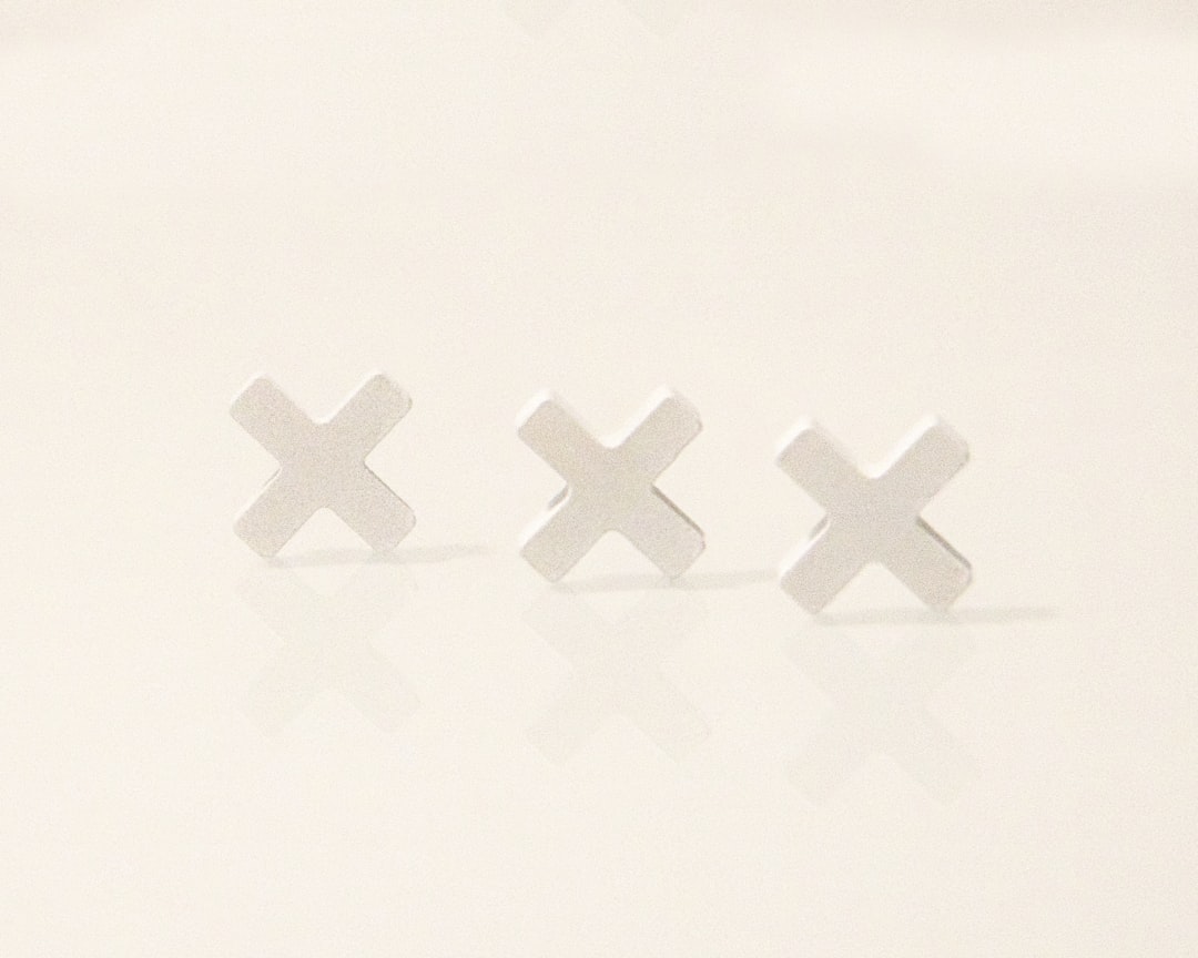 A pair of small white crosses on a white surface