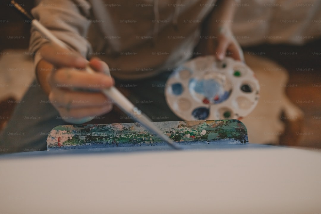 a person holding a paintbrush and a paint palette