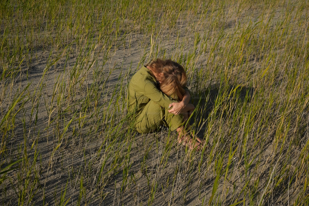 a person sitting in a field of tall grass