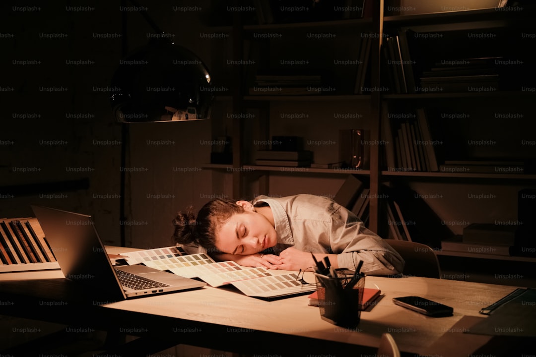 A person sleeping on a desk in a dark room