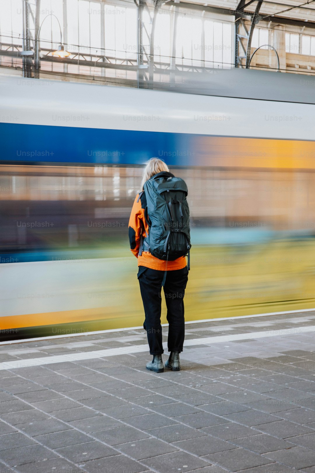 a person standing on a platform with a train in the background