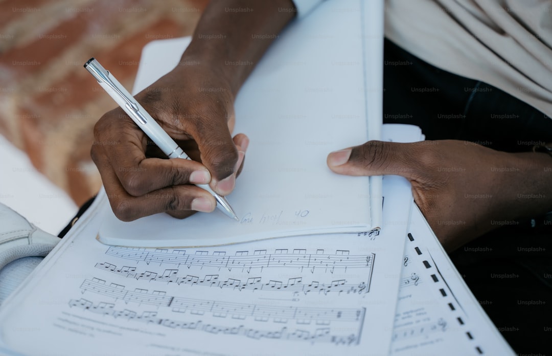 a person writing on a sheet of paper with a pen