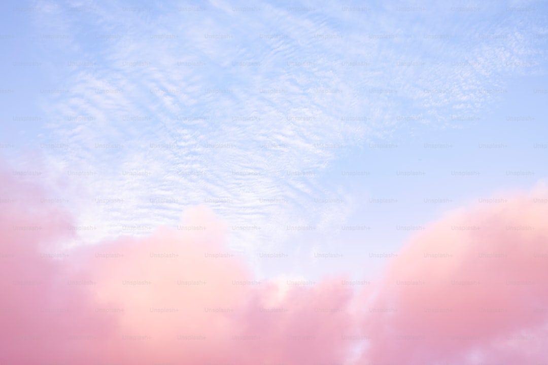 A plane flying through a blue cloudy sky