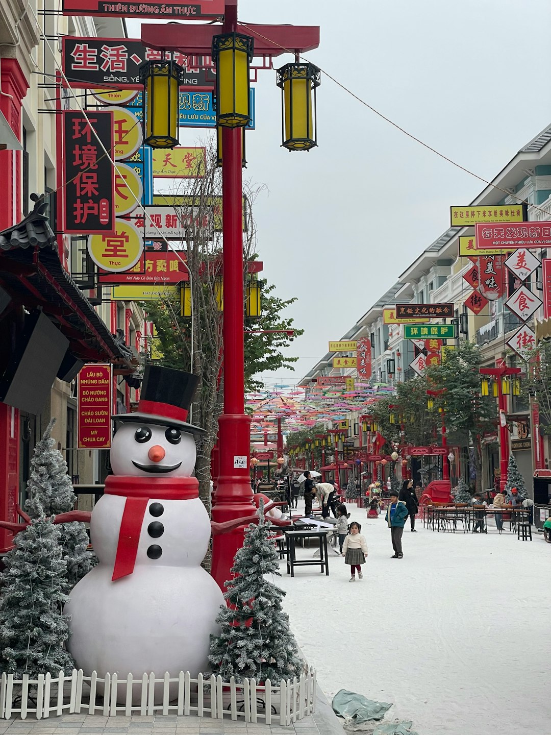 A snowman is standing in the middle of a street