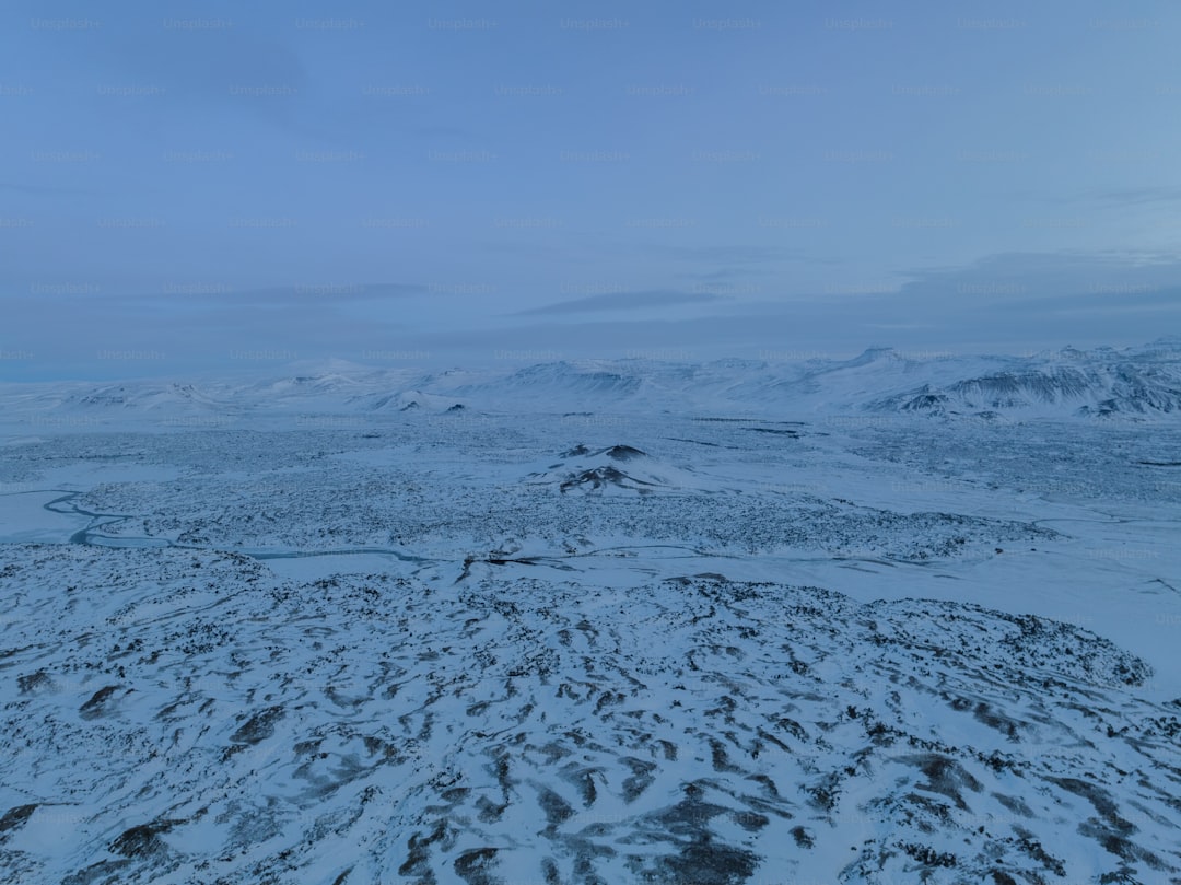 a snowy landscape with mountains in the distance