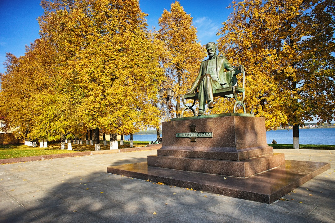 a statue of a man sitting on top of a bench