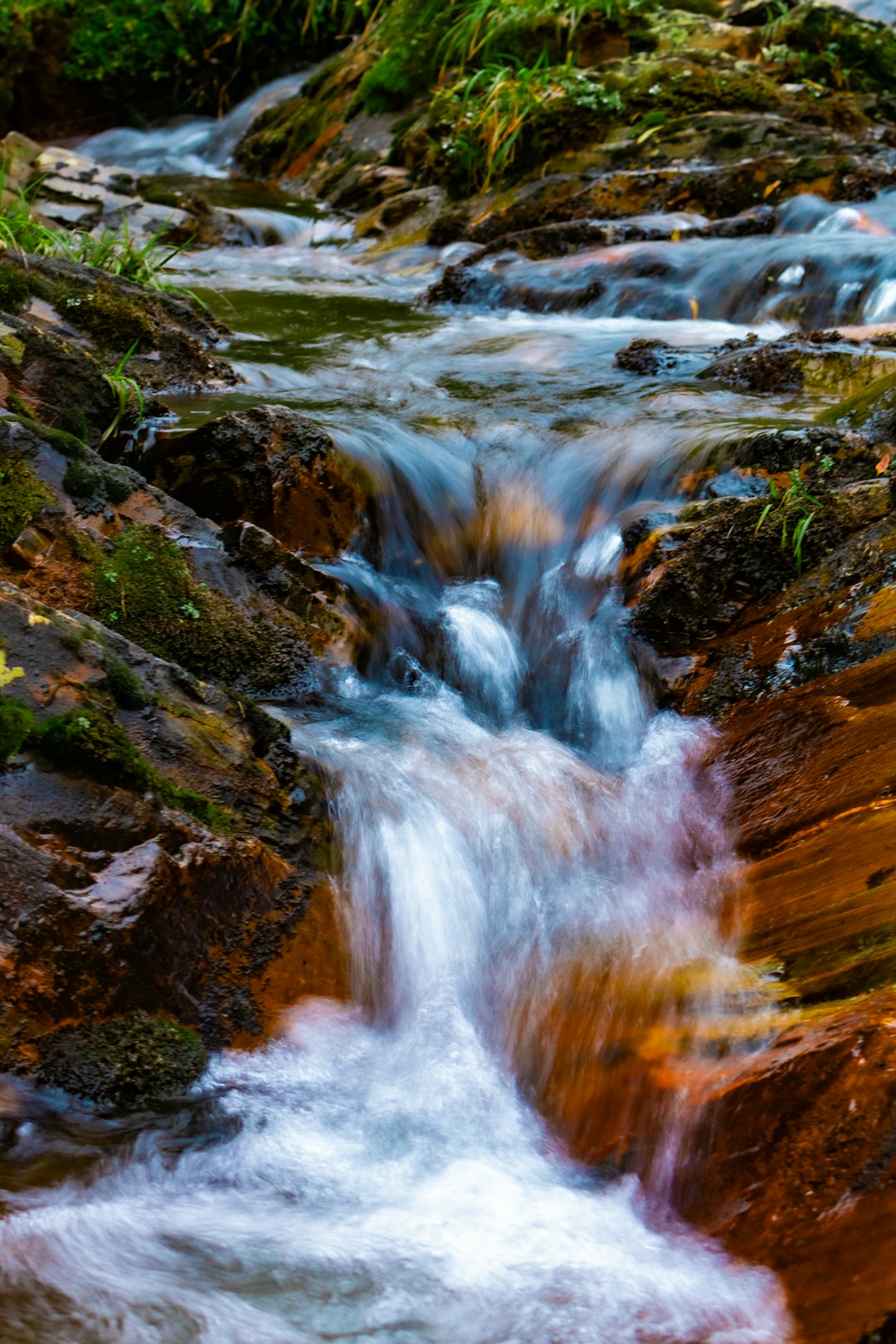 a stream of water running over rocks in a forest