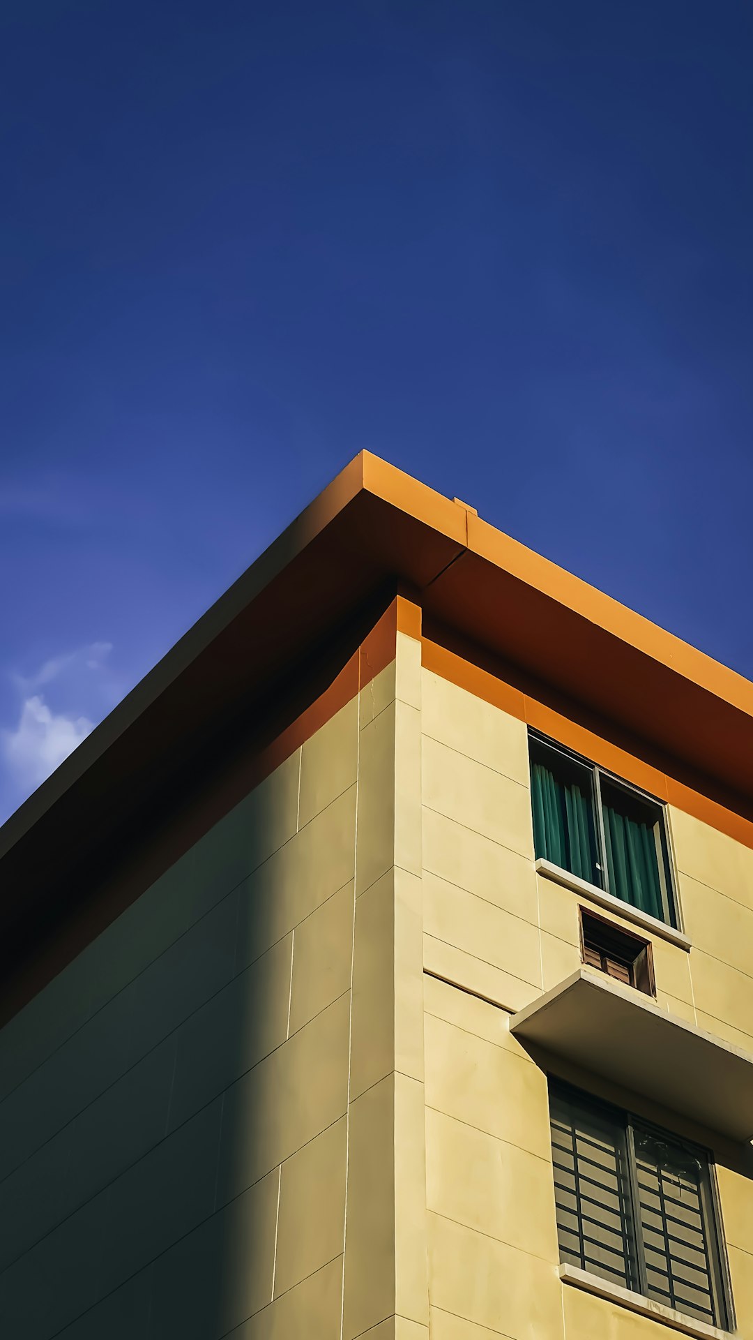 a tall building with a window and a sky background