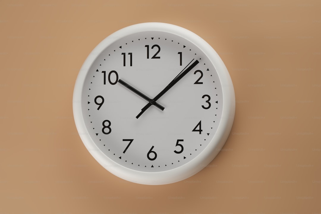 A white clock with black hands on a wall