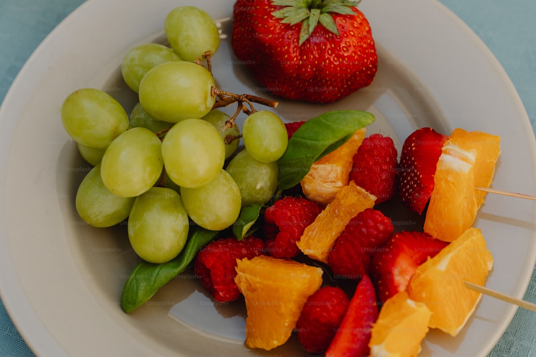 a white plate topped with grapes and oranges