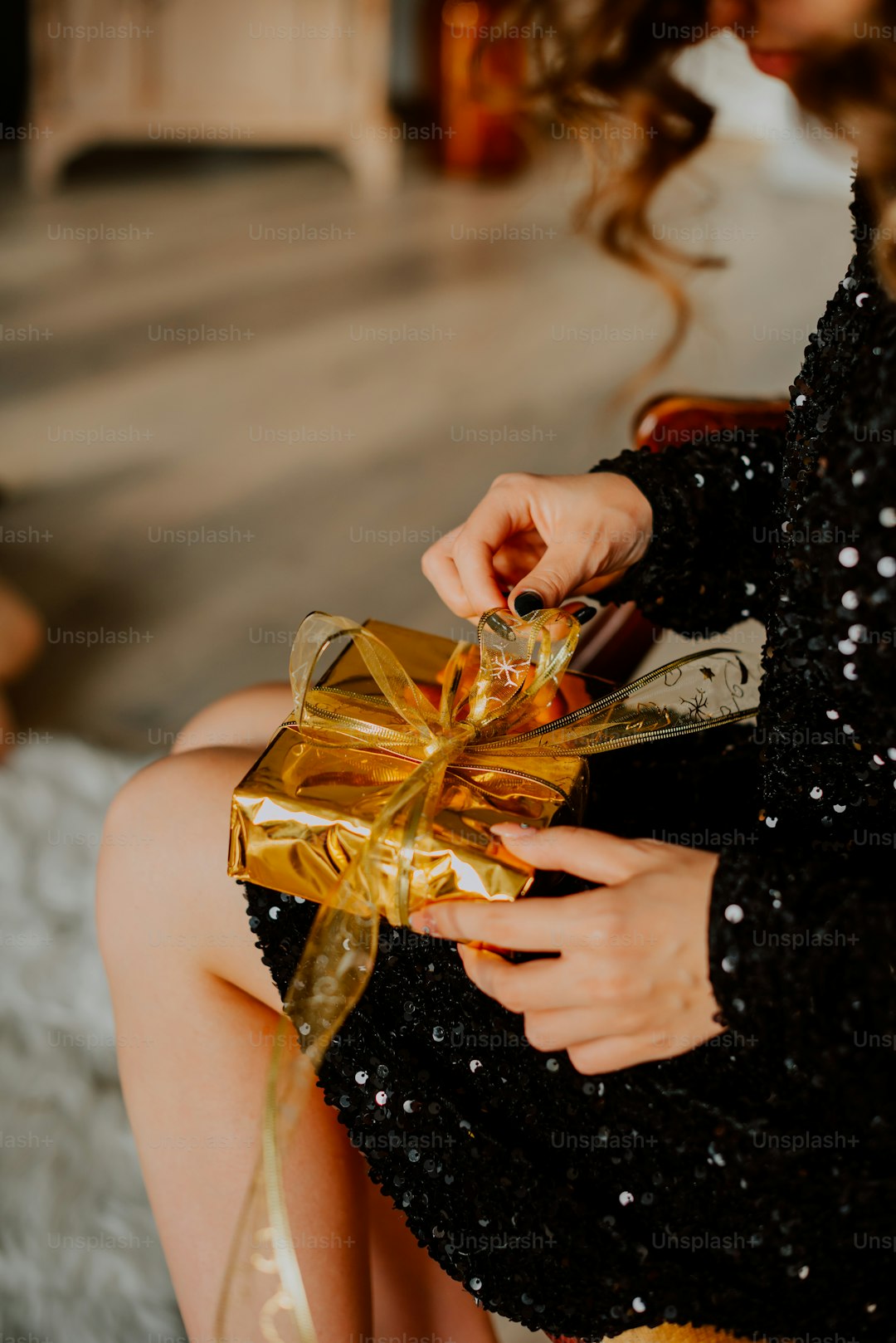 a woman in a black dress holding a gold bow