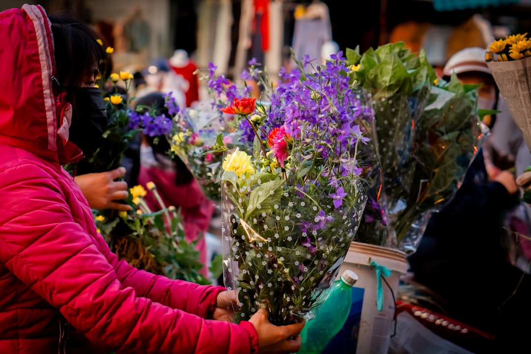 A woman in a red jacket holding a bunch of flowers