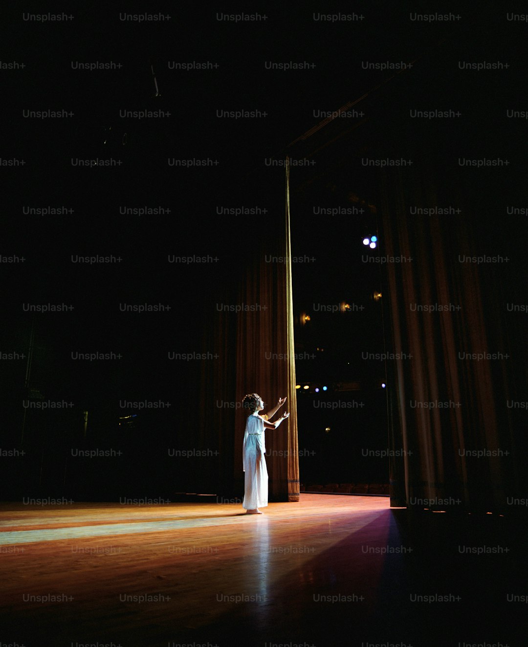 a woman in a white dress standing on a stage