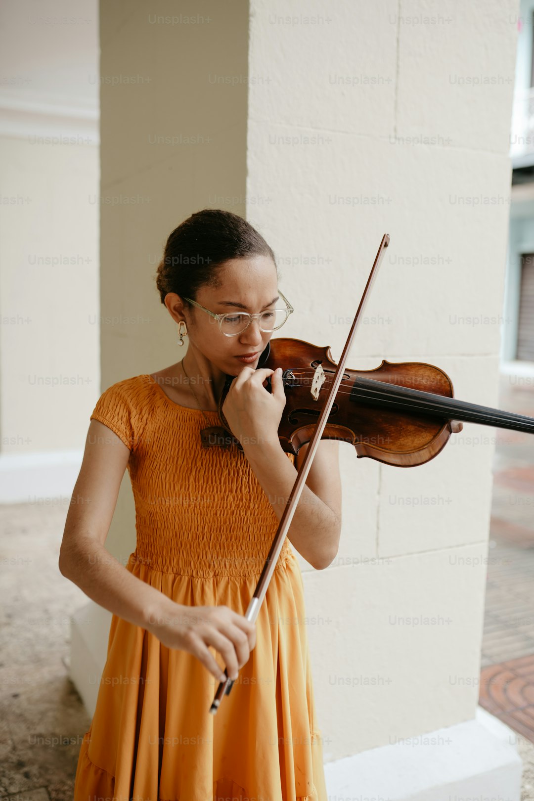 a woman in an orange dress playing a violin