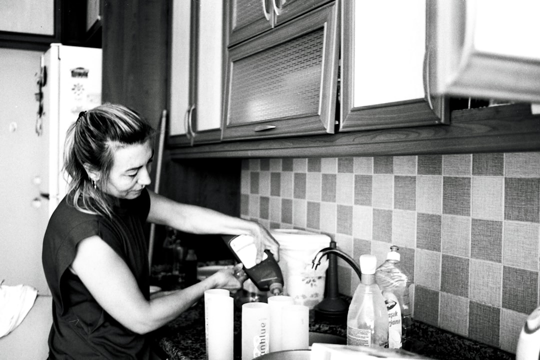 a woman is washing dishes in the kitchen